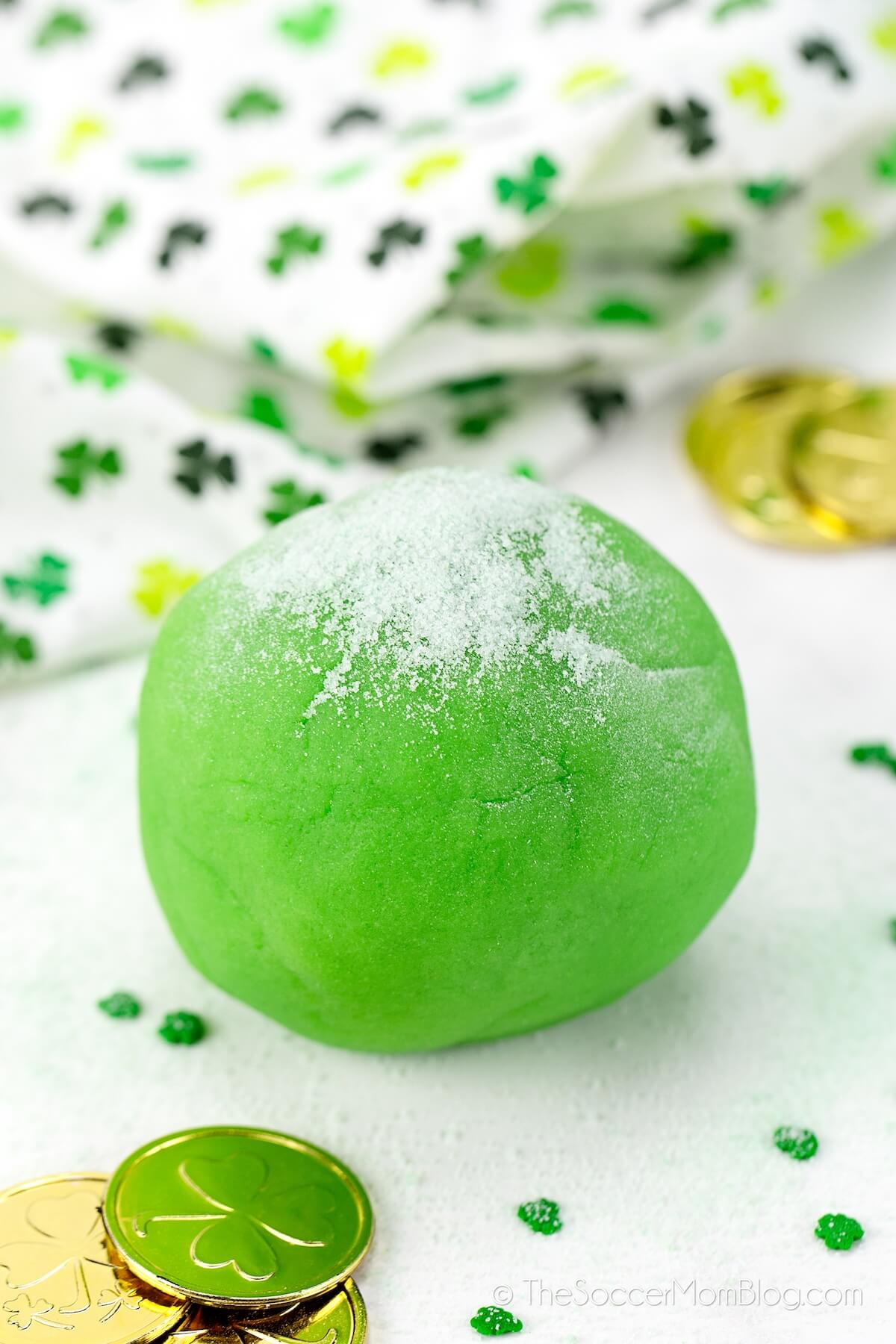 ball of lime green playdough with St. Patrick's Day themed decor
