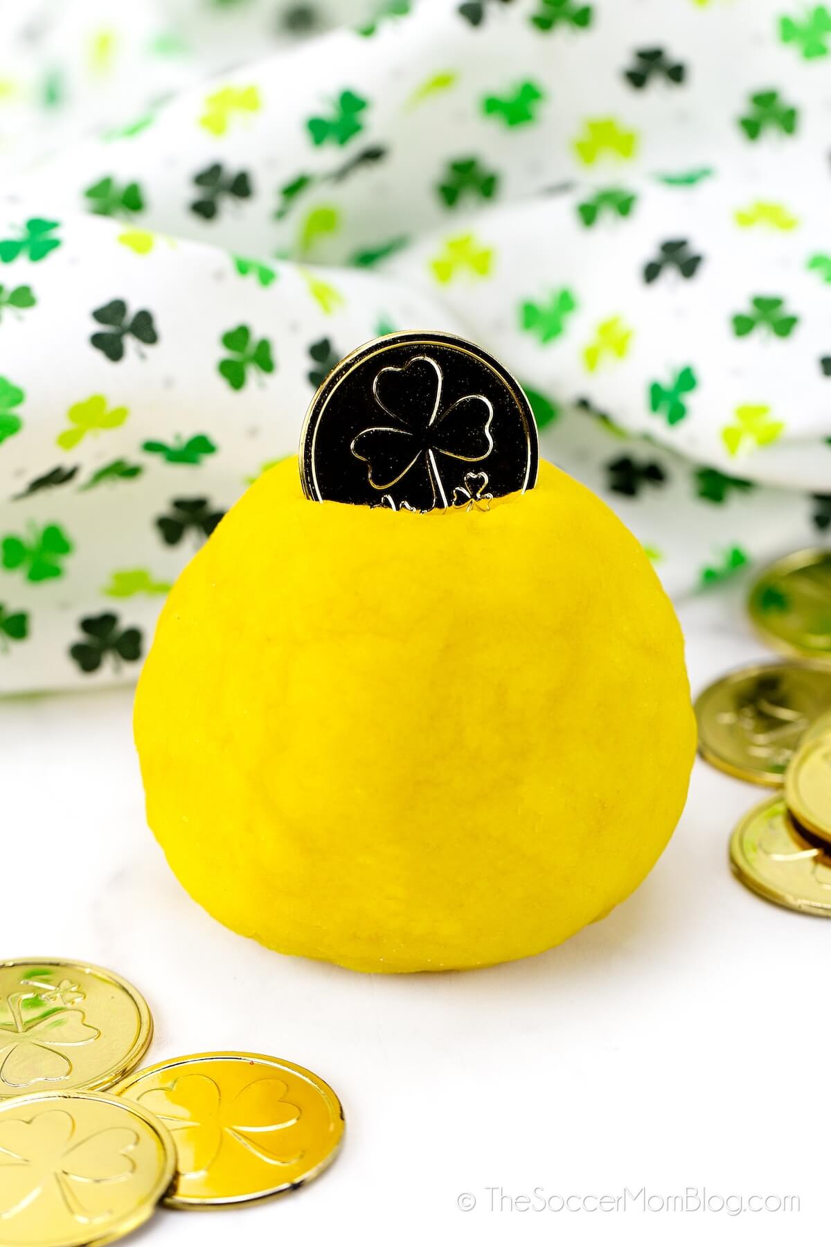 ball of yellow playdough with a gold coin on top