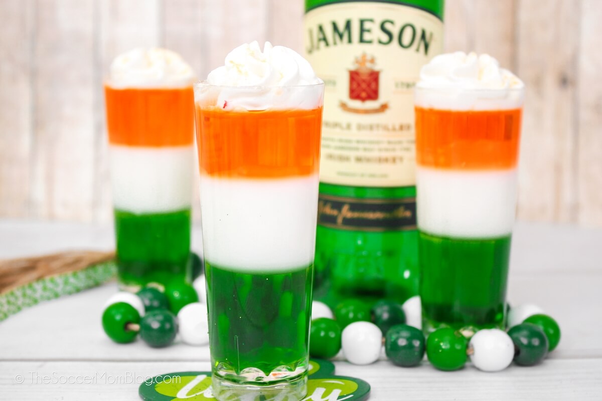 orange, white and green layered jello shots with Jameson bottle in background