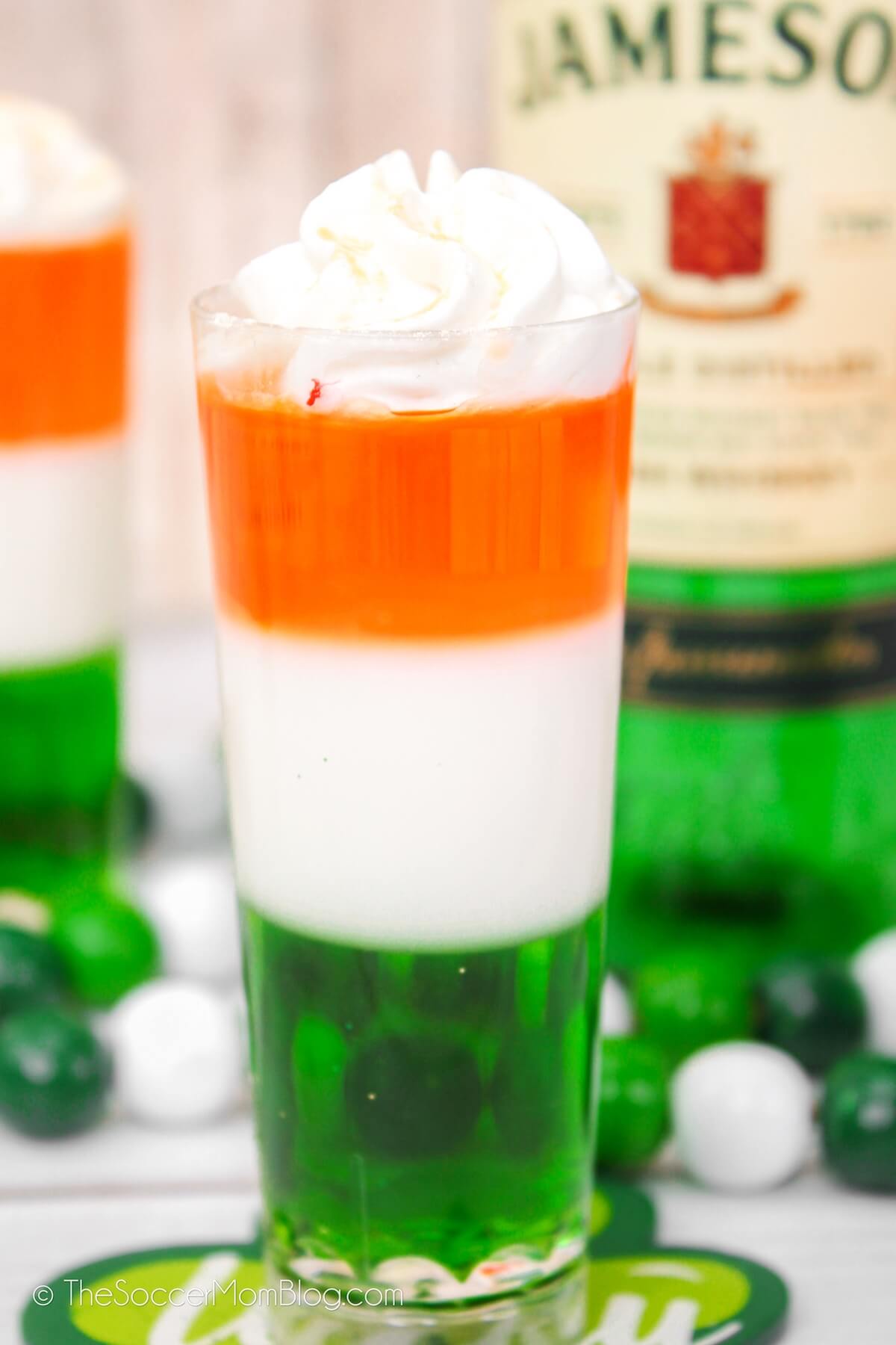close up of a layered orange, white, and green jello shot