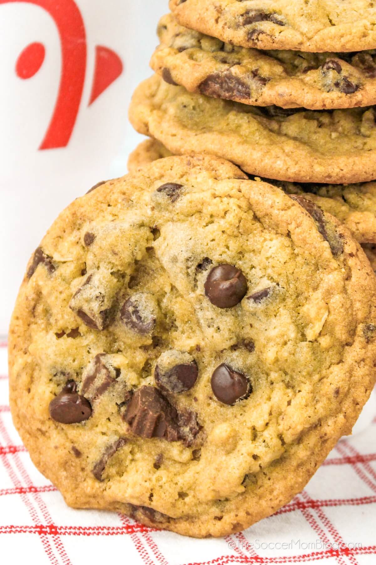 close up of a chocolate chip cookie in front of a stack of cookies