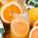 mason jar with grapefruit juice drink and fresh grapefruit slices