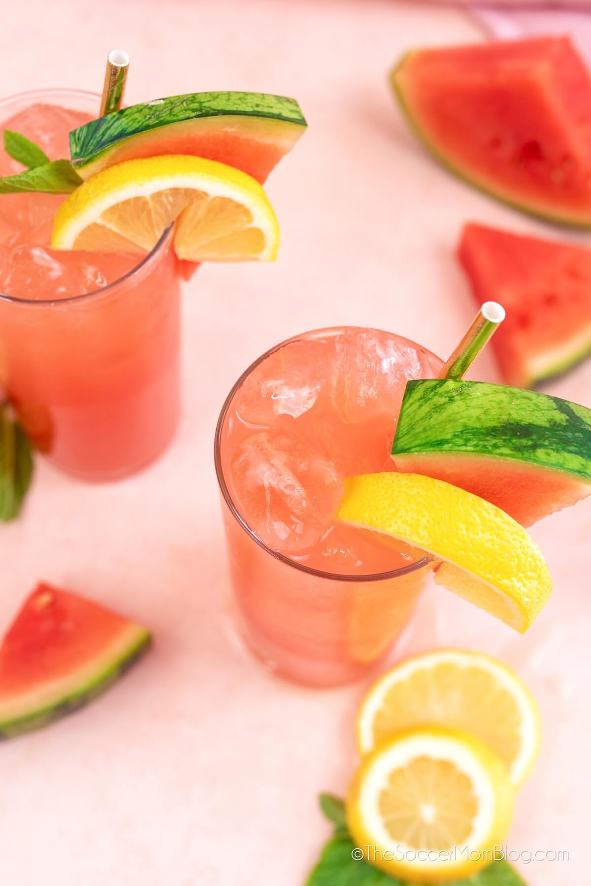 top down view of two glasses of watermelon mint lemonade, surrounded by fruit
