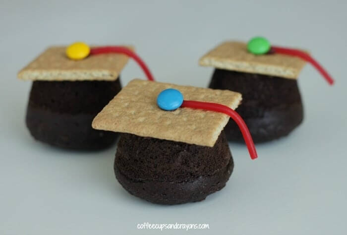 cupcakes topped with graham cracker and candy to look like a graduation cap