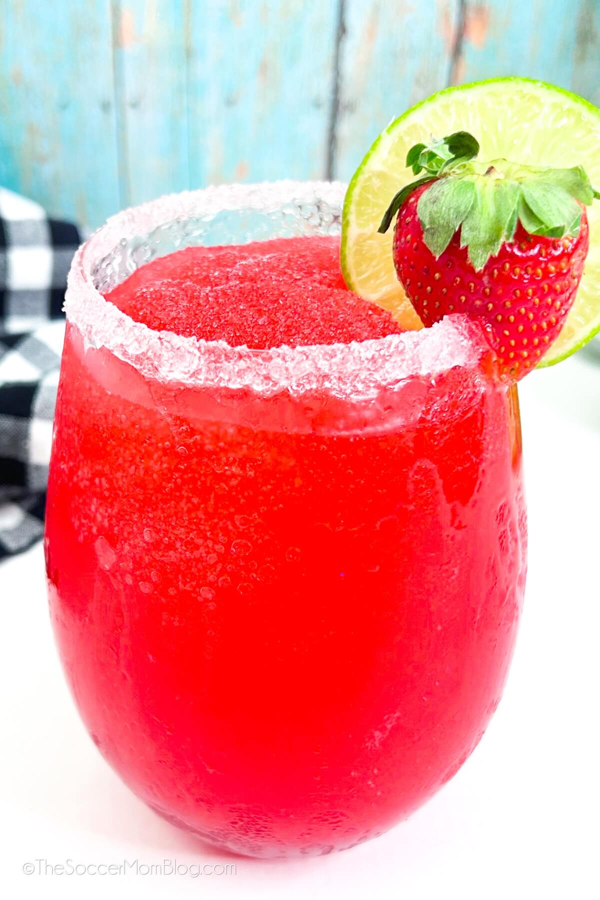 close up of a frozen strawberry margarita with salt rim and fresh fruit