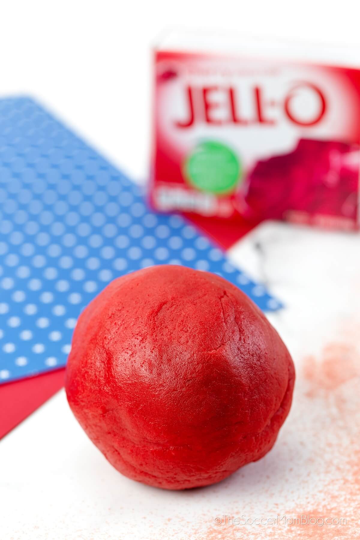 ball of red playdough, with box of cherry jello in background