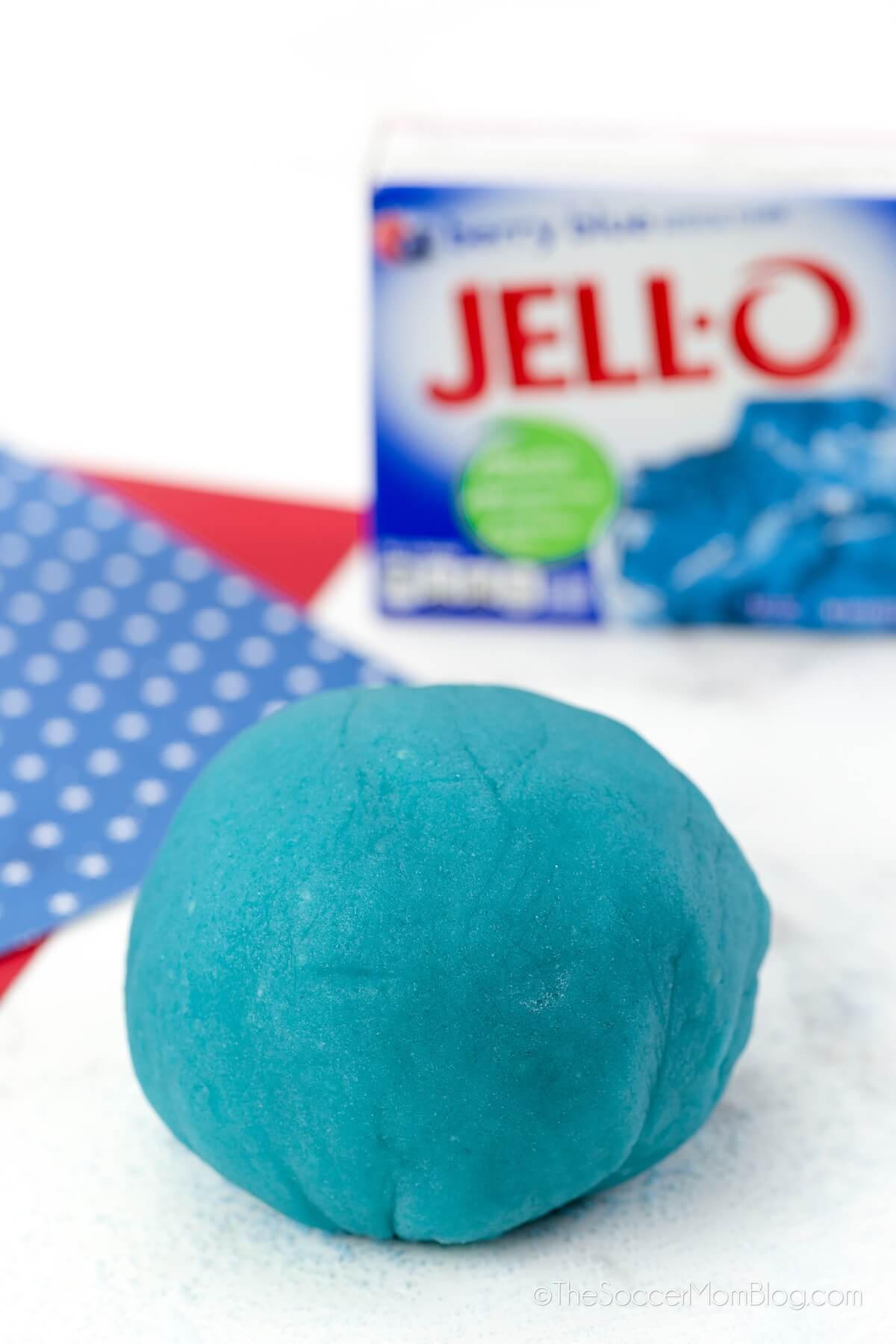 ball of blue playdough with box of blue raspberry jello in background
