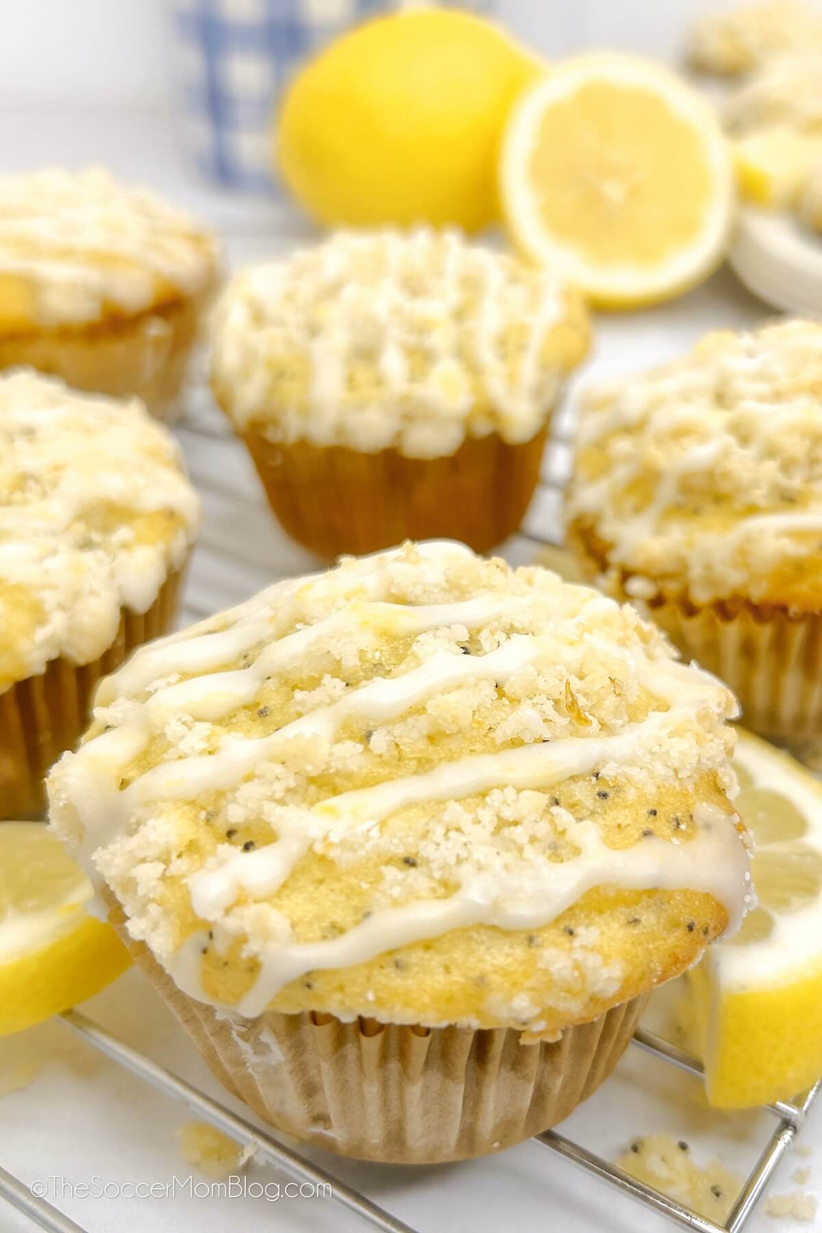 close up of a batch of glazed lemon poppyseed muffins on a cooling rack