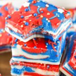 stack of red white and blue swirled fudge squares, top piece has a bite taken