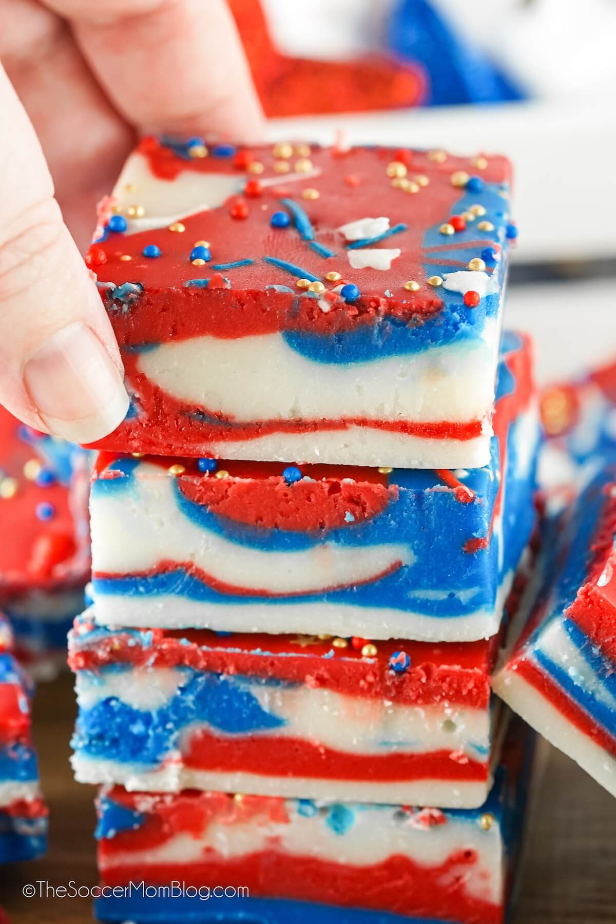 stack of 4th of July fudge, with a hand grabbing the top piece