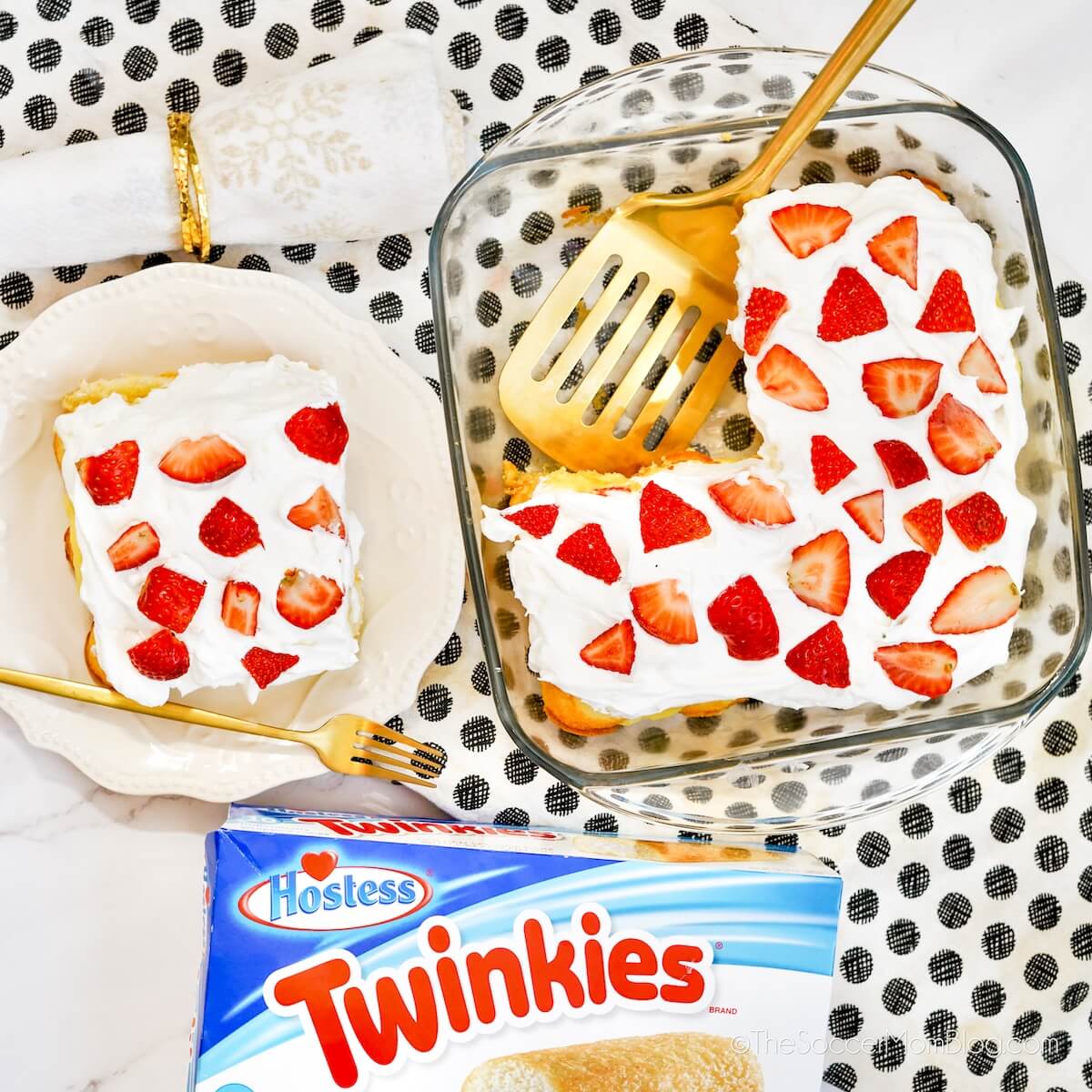 top down view of a cake made with Twinkies, whipped topping, and strawberries - next to a box of Twinkies