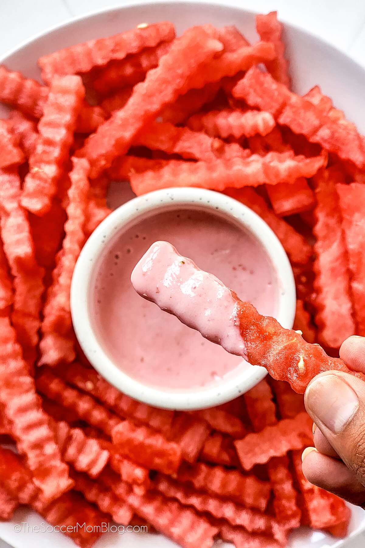 platter of watermelon fries, one dipped in strawberry sauce