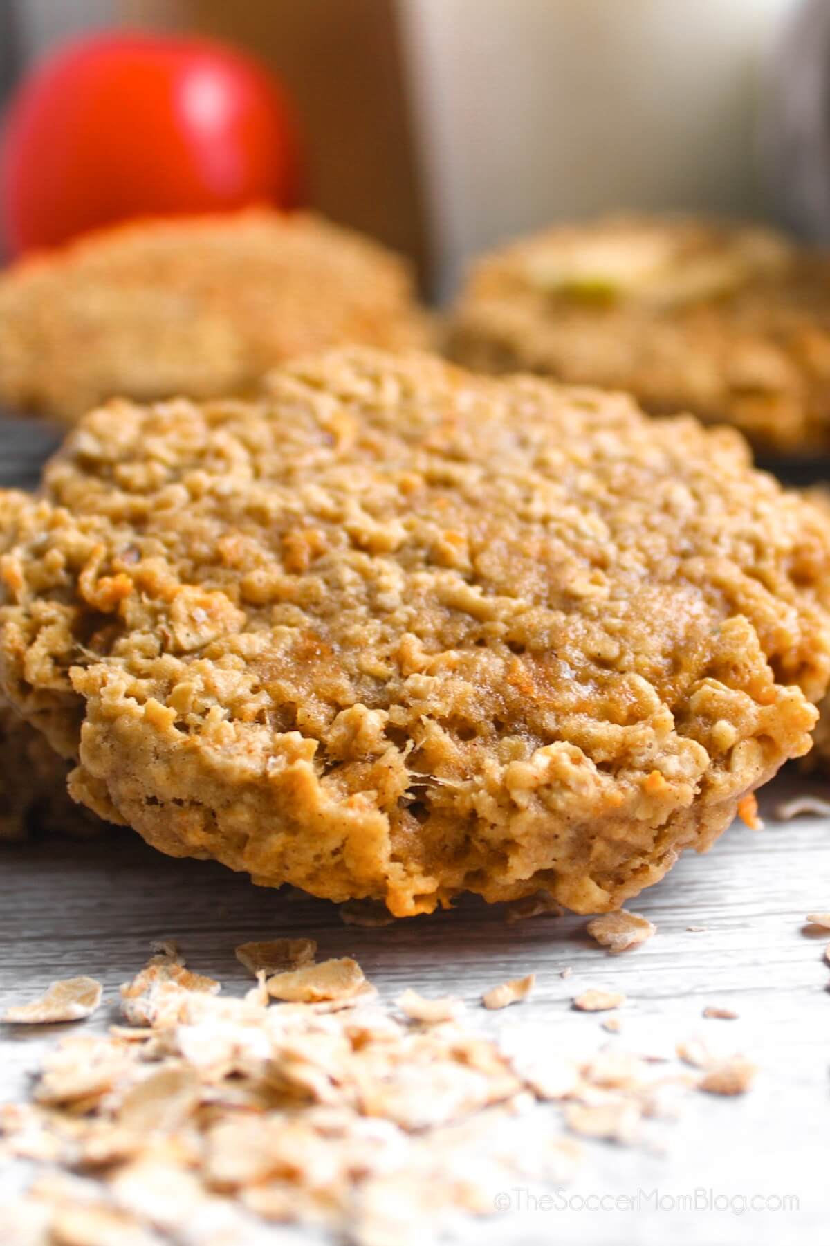 close up of an apple oatmeal cookie, apple in background