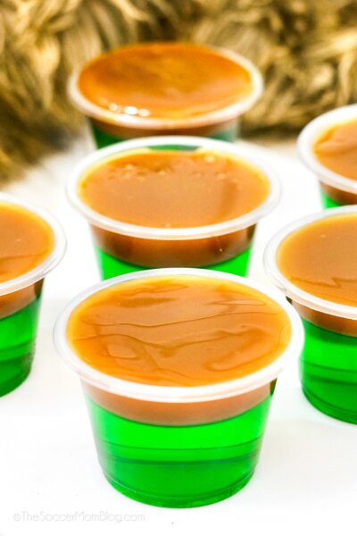 caramel apple jello shots, with green apple jello topped with caramel sauce