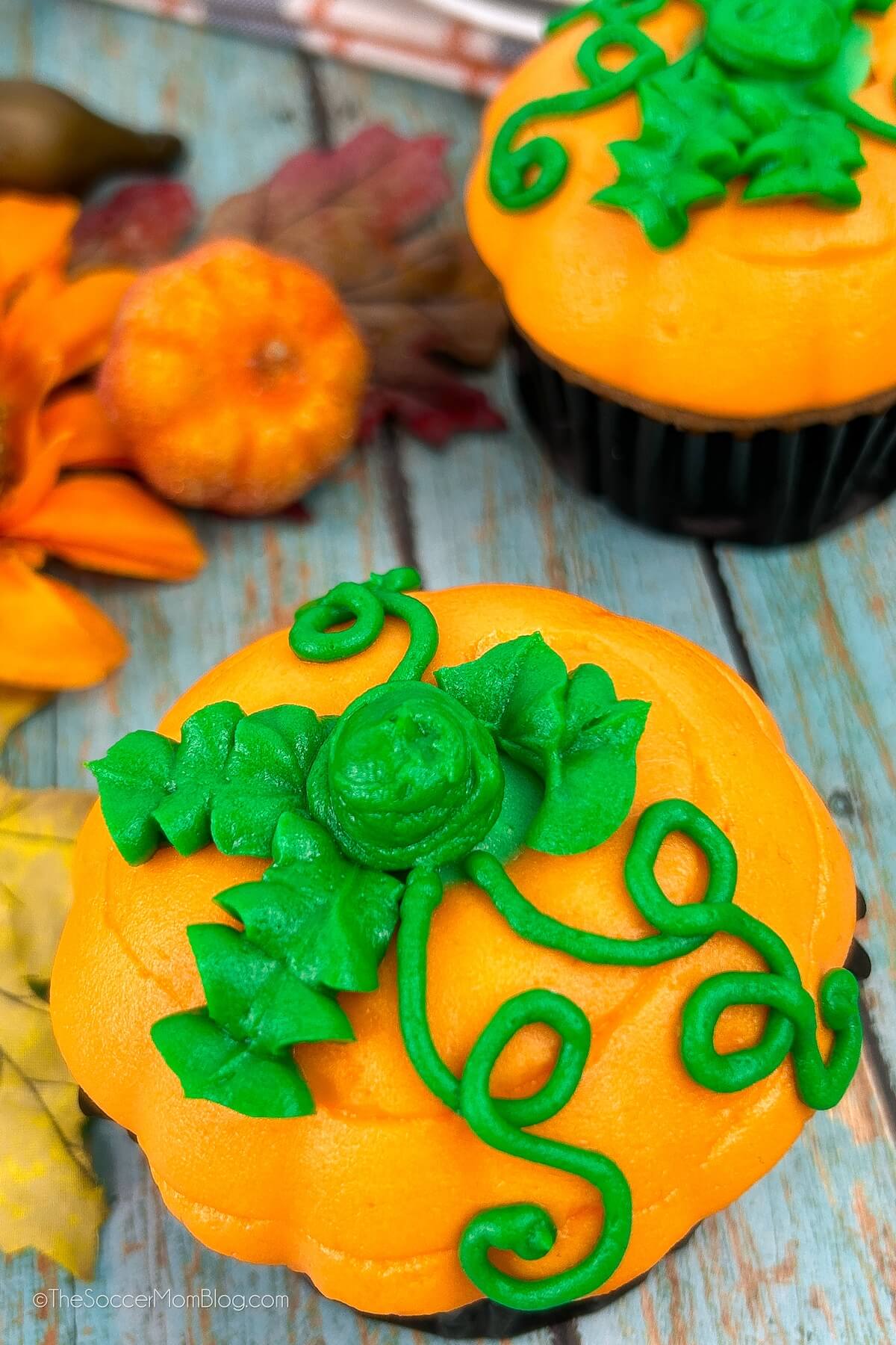 frosting shaped to look like a pumpkin on top of a cupcake.
