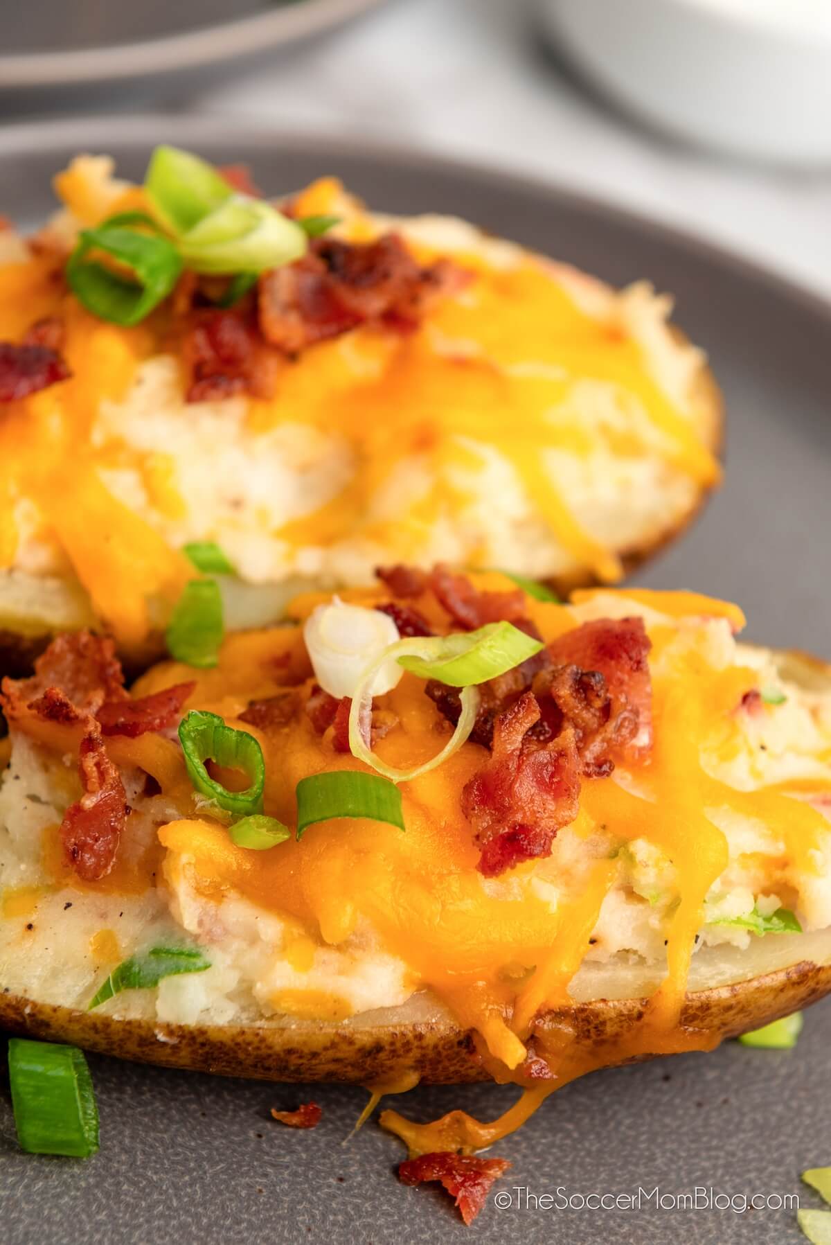 close up of stuffed baked potato shells with cheese.