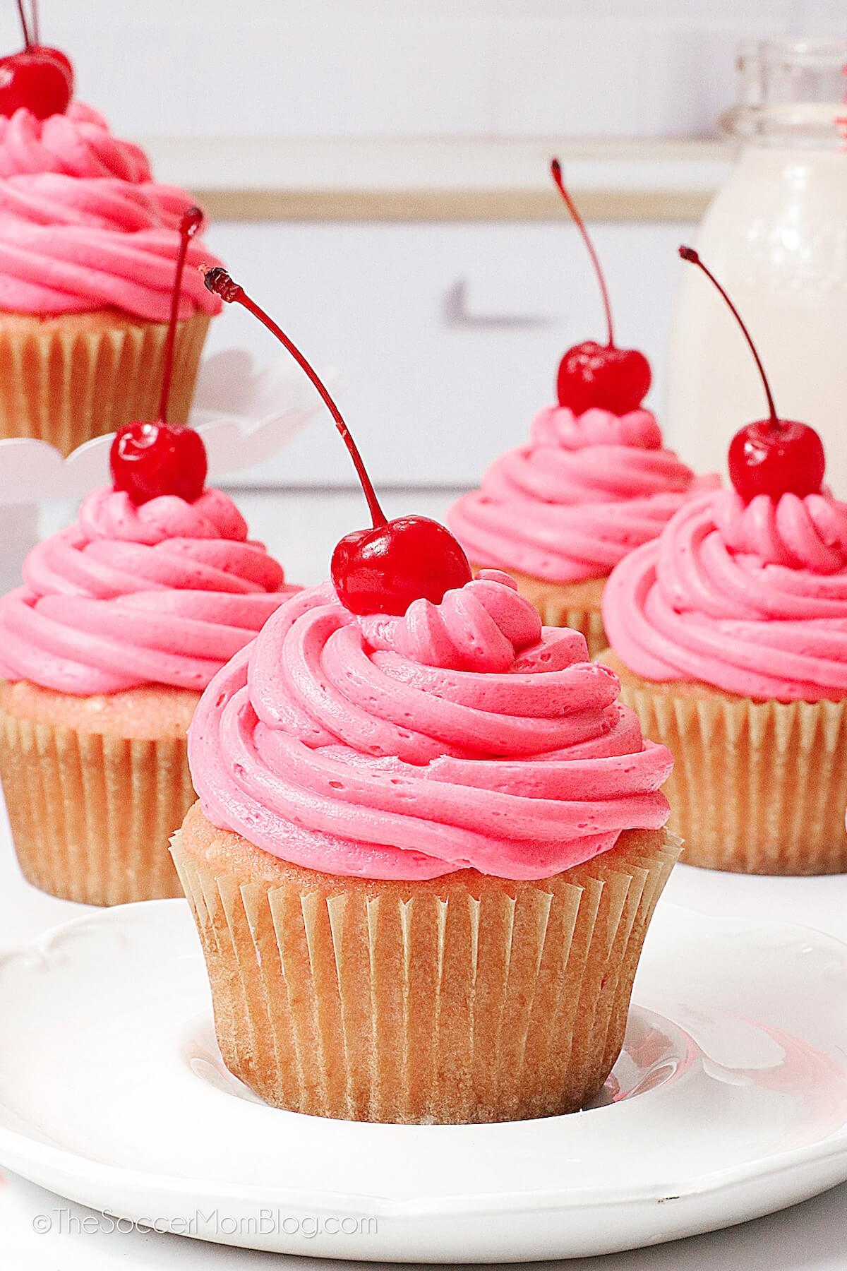 Cherry Cupcakes on plate, with pink icing.