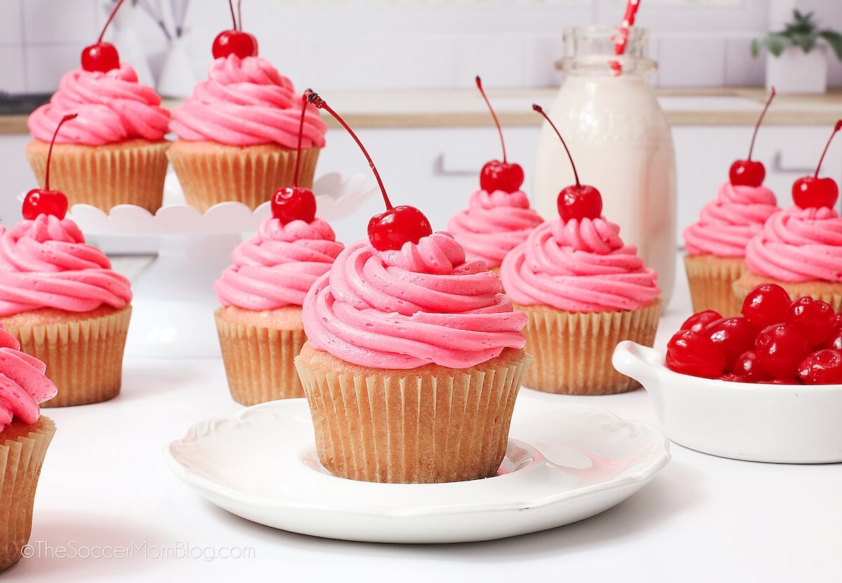 Cherry Cupcakes, topped with pink frosting and a maraschino cherry.