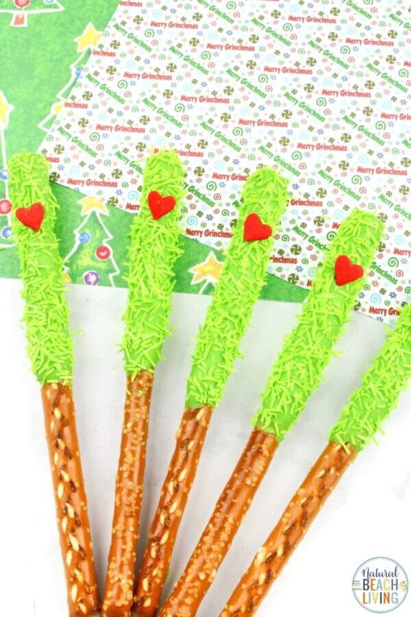 pretzel rods dipped in lime green chocolate and topped with a red candy heart.