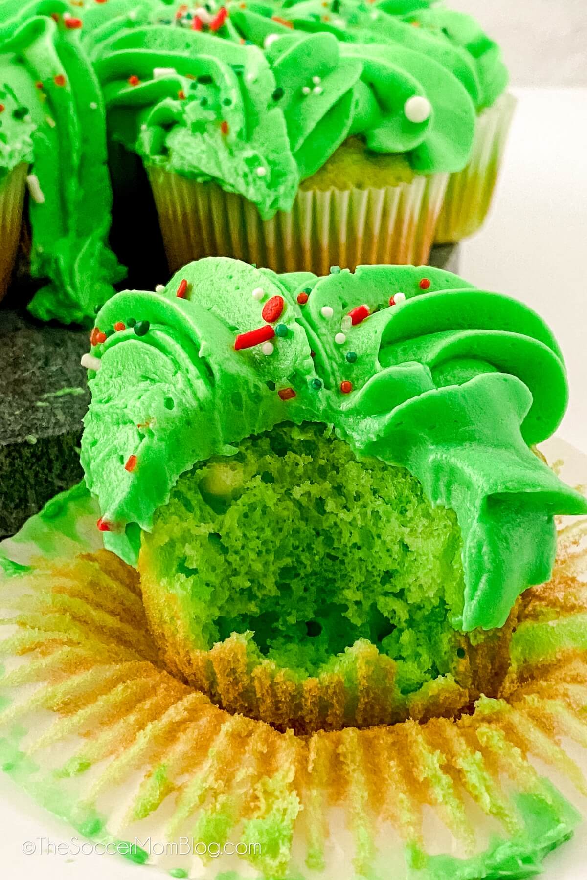 green cupcake with green frosting, with a bite taken.