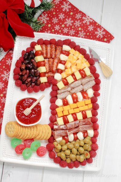 charcuterie board made with red and white ingredients and shaped like a candy cane.