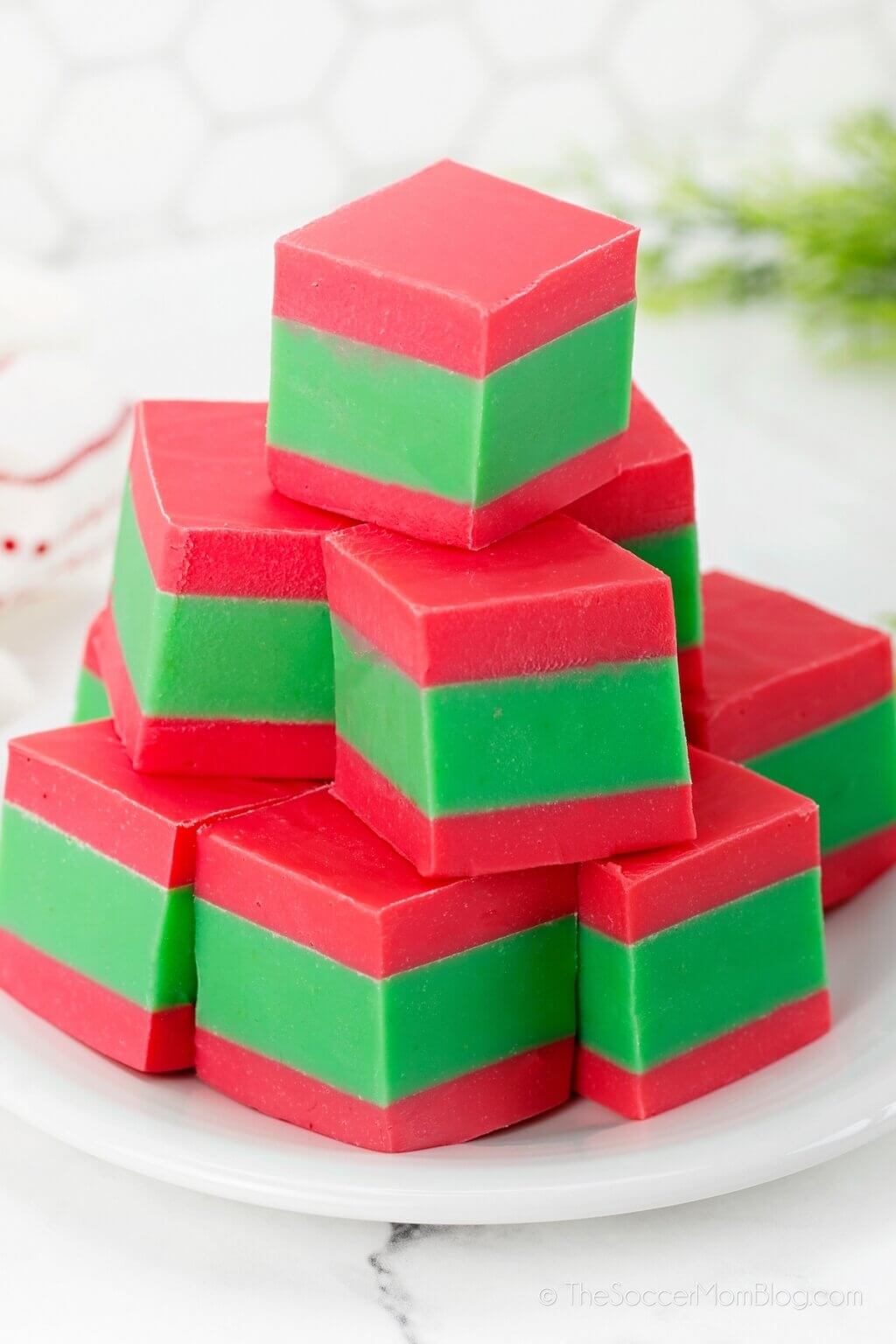 stack of red and green striped Christmas fudge on plate.