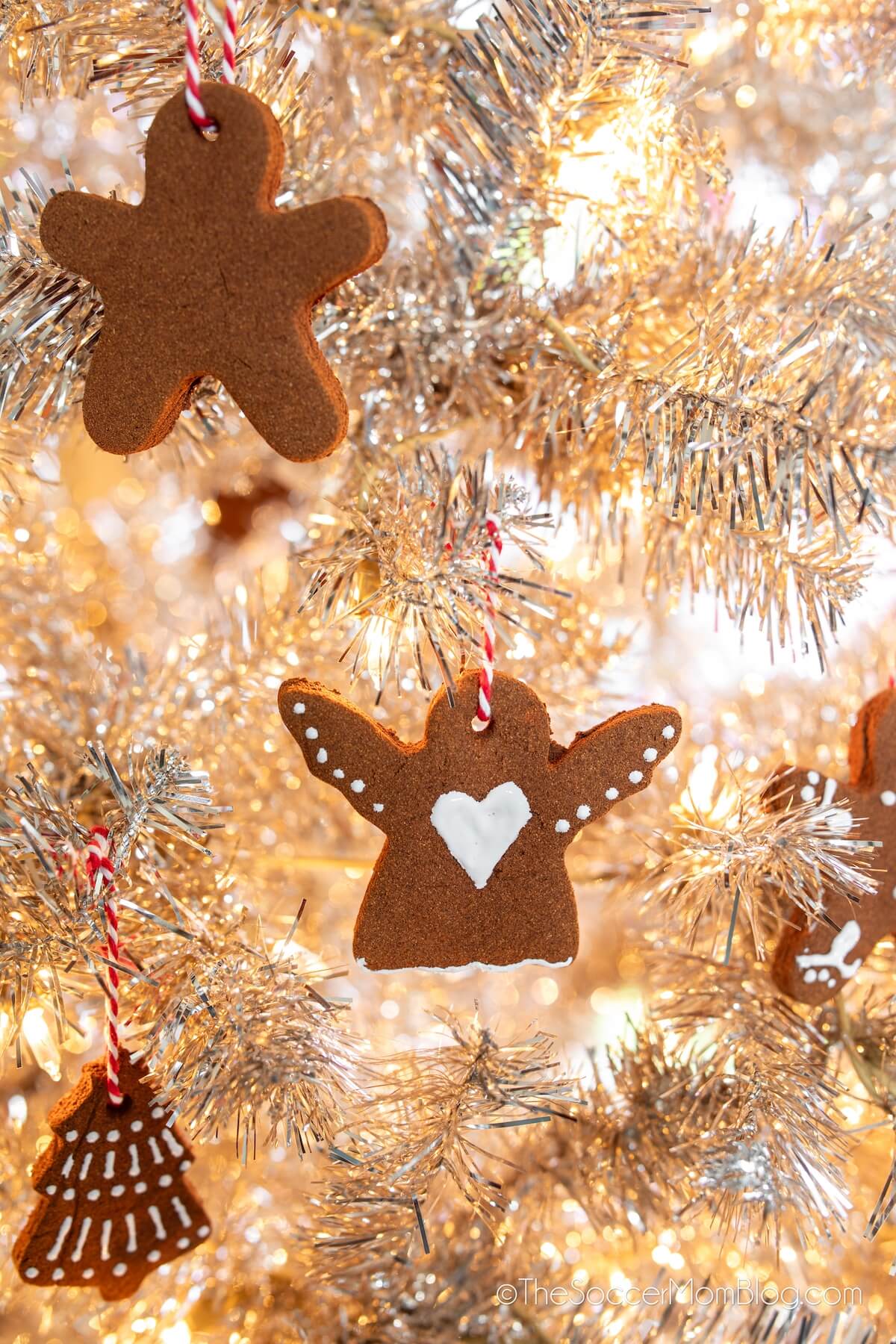 cinnamon ornaments hanging on a white Christmas tree.