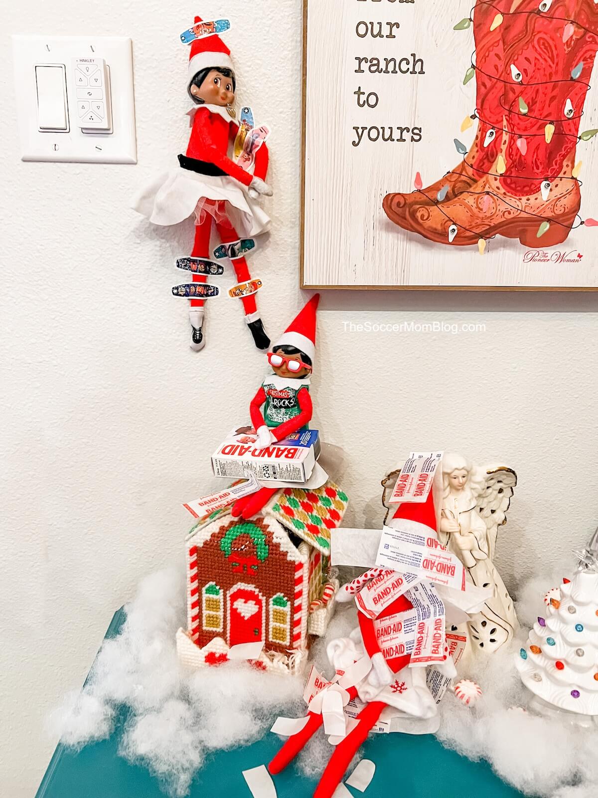 elf on the shelf doll stuck to the wall with band-aids.