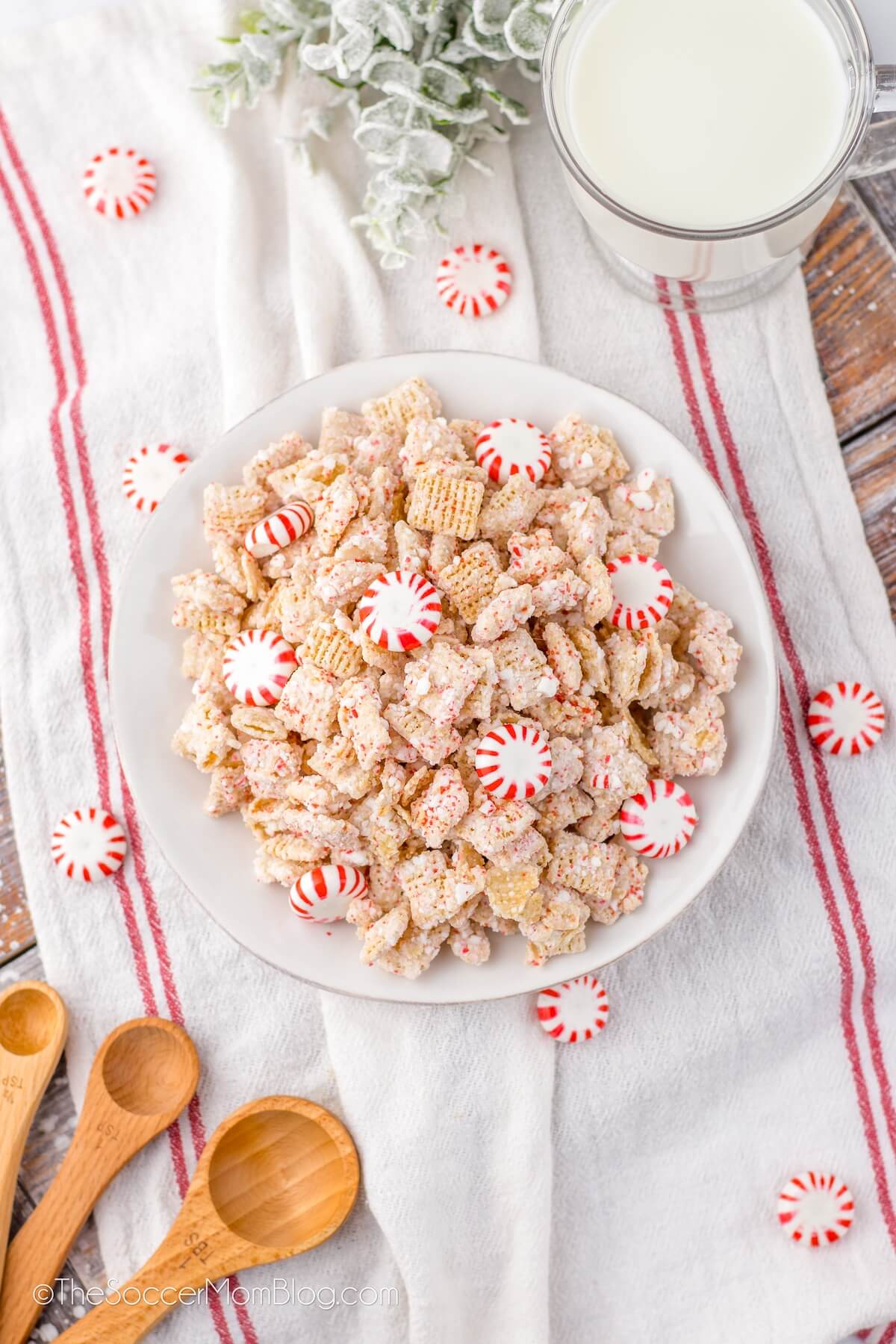 a bowl of candy cane Chex mix on a festive dish towel.