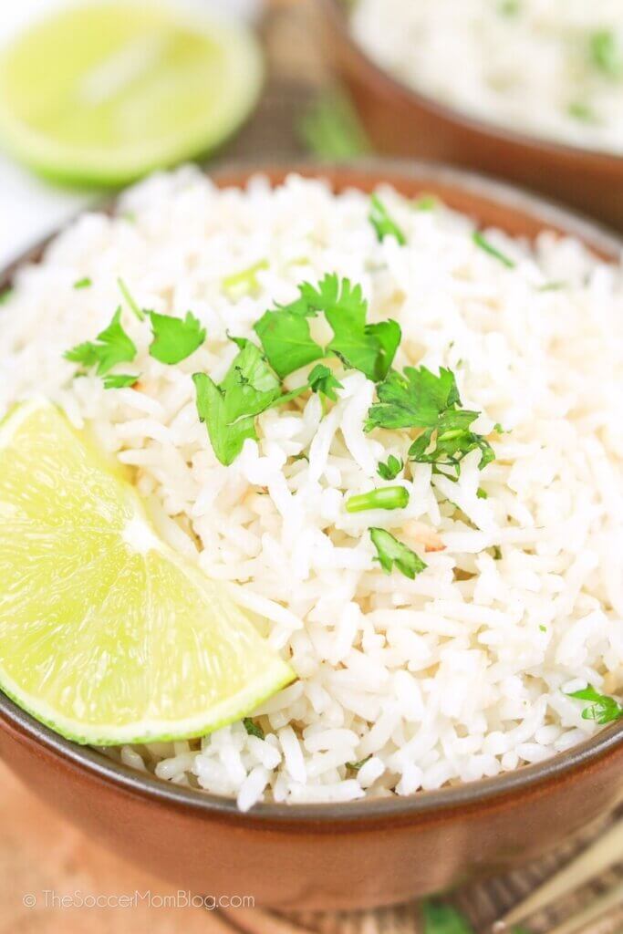 bowl of rice with lime wedge and cilantro.