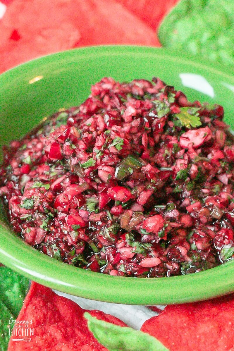 cranberry salsa surrounded by red and green tortilla chips.