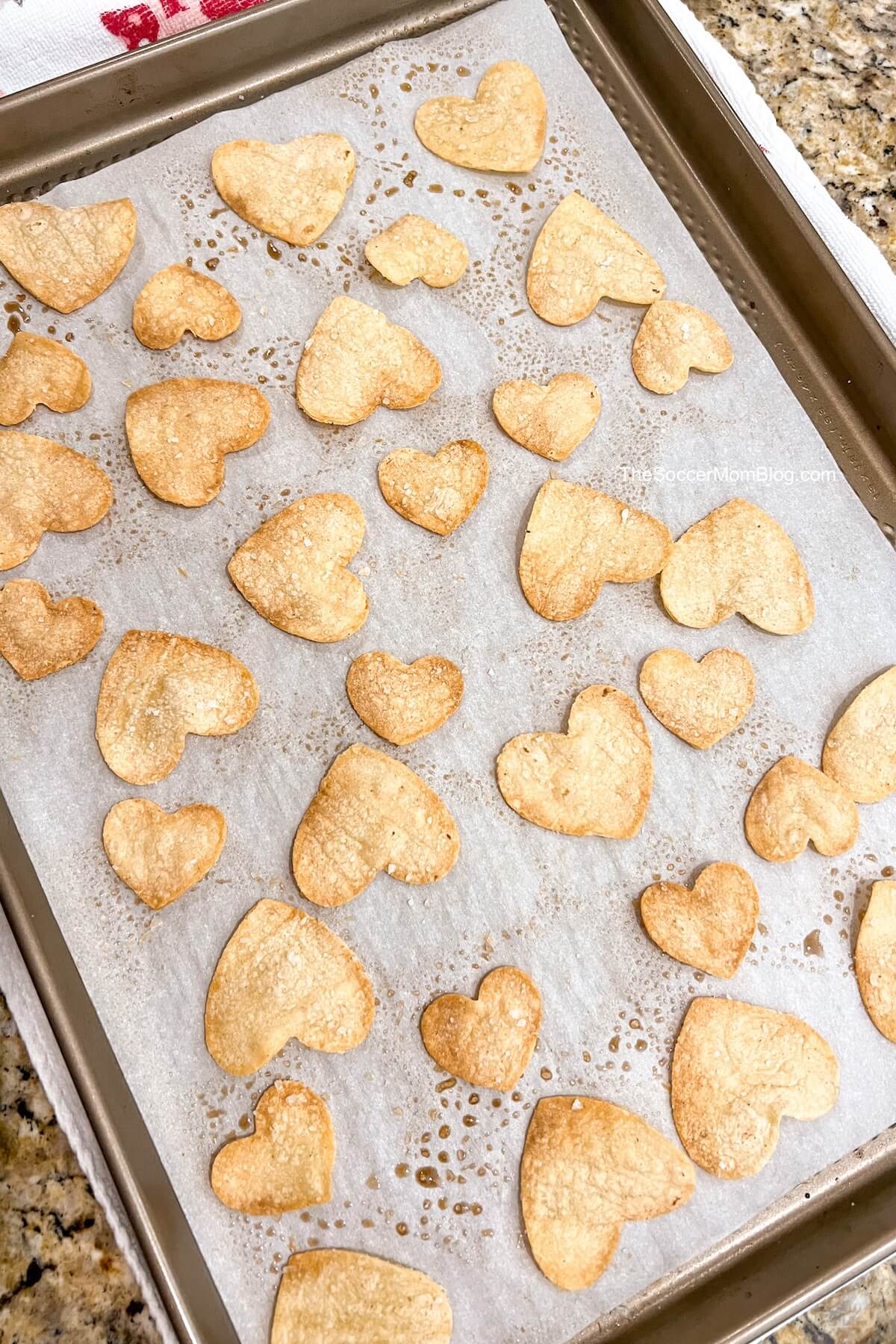 heart shaped tortilla chips on a baking sheet.