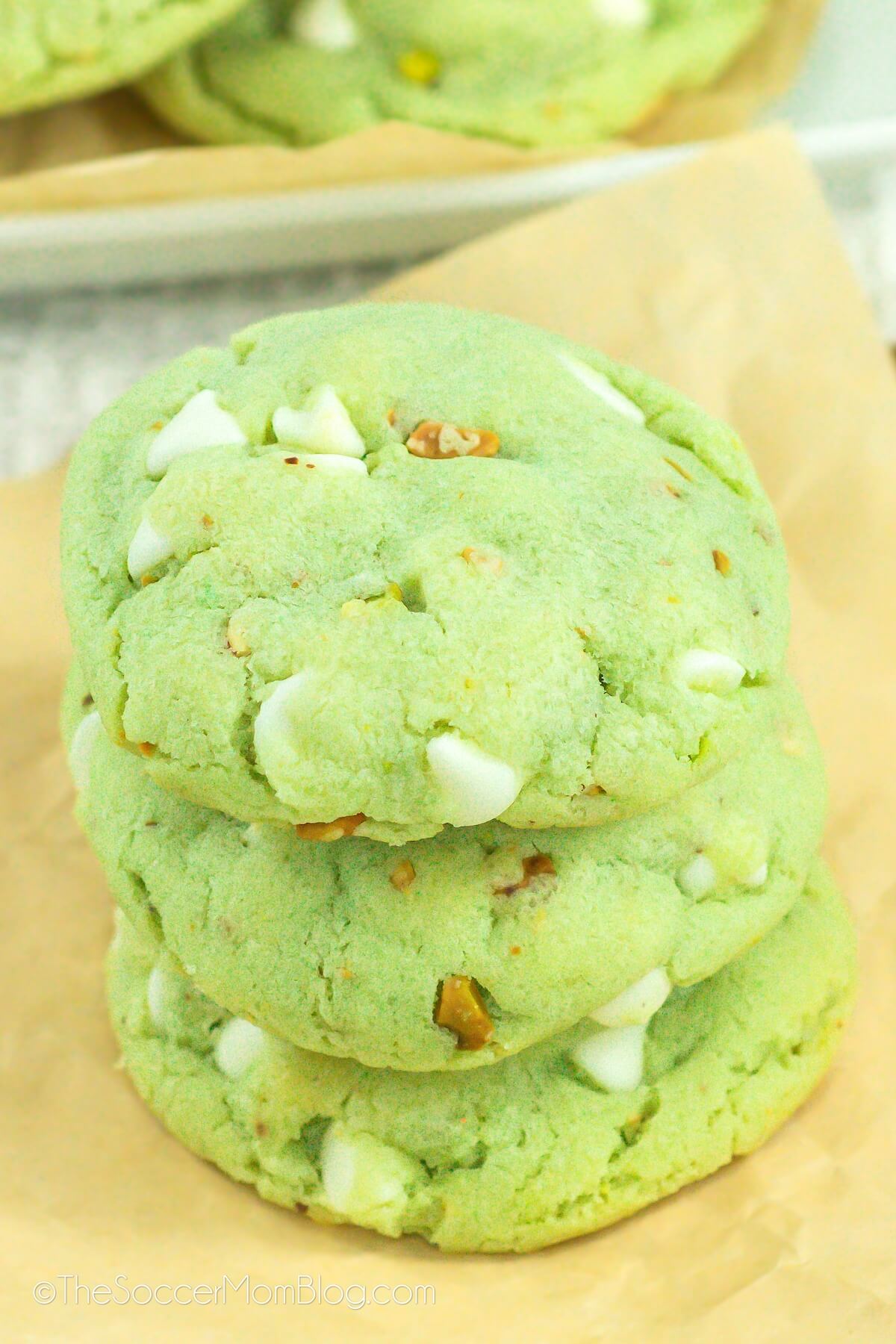 stack of 3 green Pistachio Pudding Cookies with nuts and white chocolate chips.