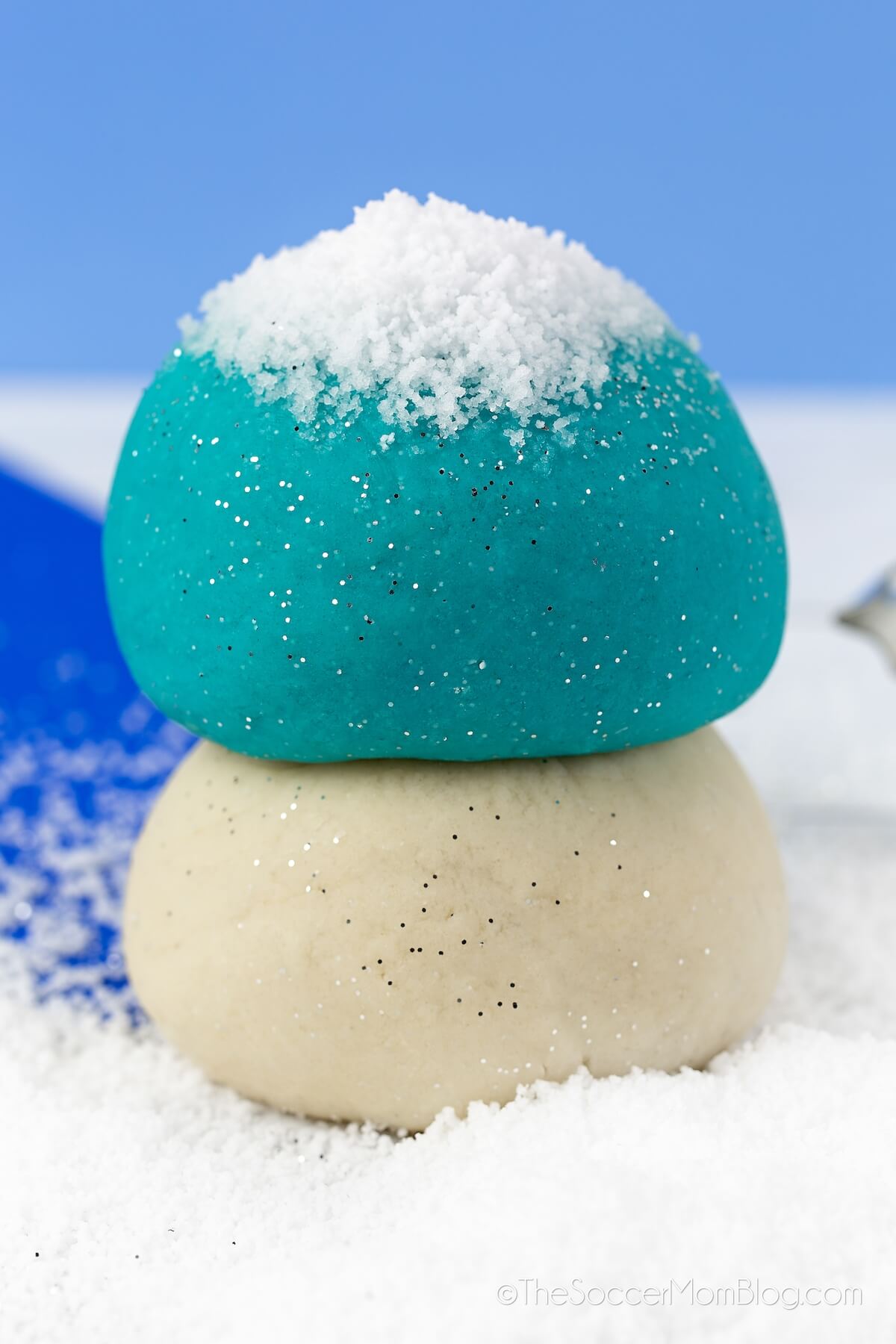 Stack of blue and white balls of playdough, surrounded by instant snow.