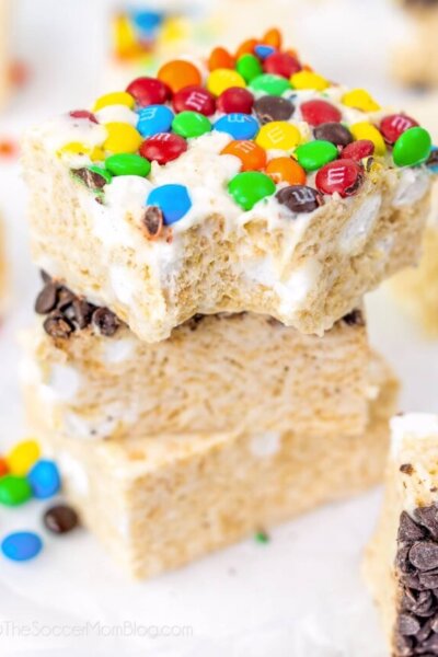 stack of 3 rice krispie treat squares, top one with M&Ms and a bite taken.