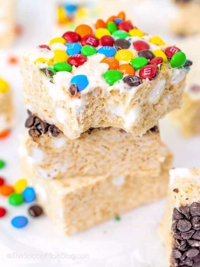 stack of 3 rice krispie treat squares, top one with M&Ms and a bite taken.