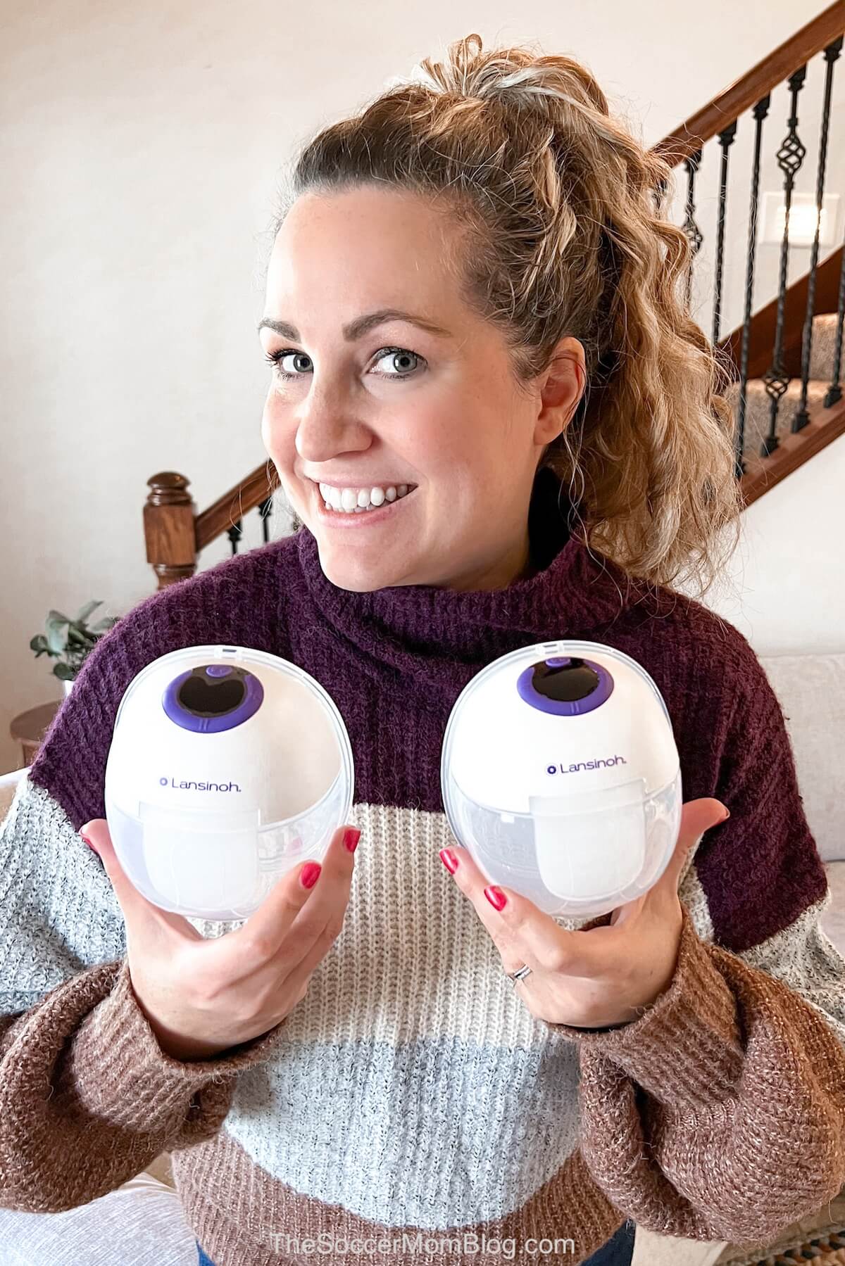 woman holding up wearable breast pumps.