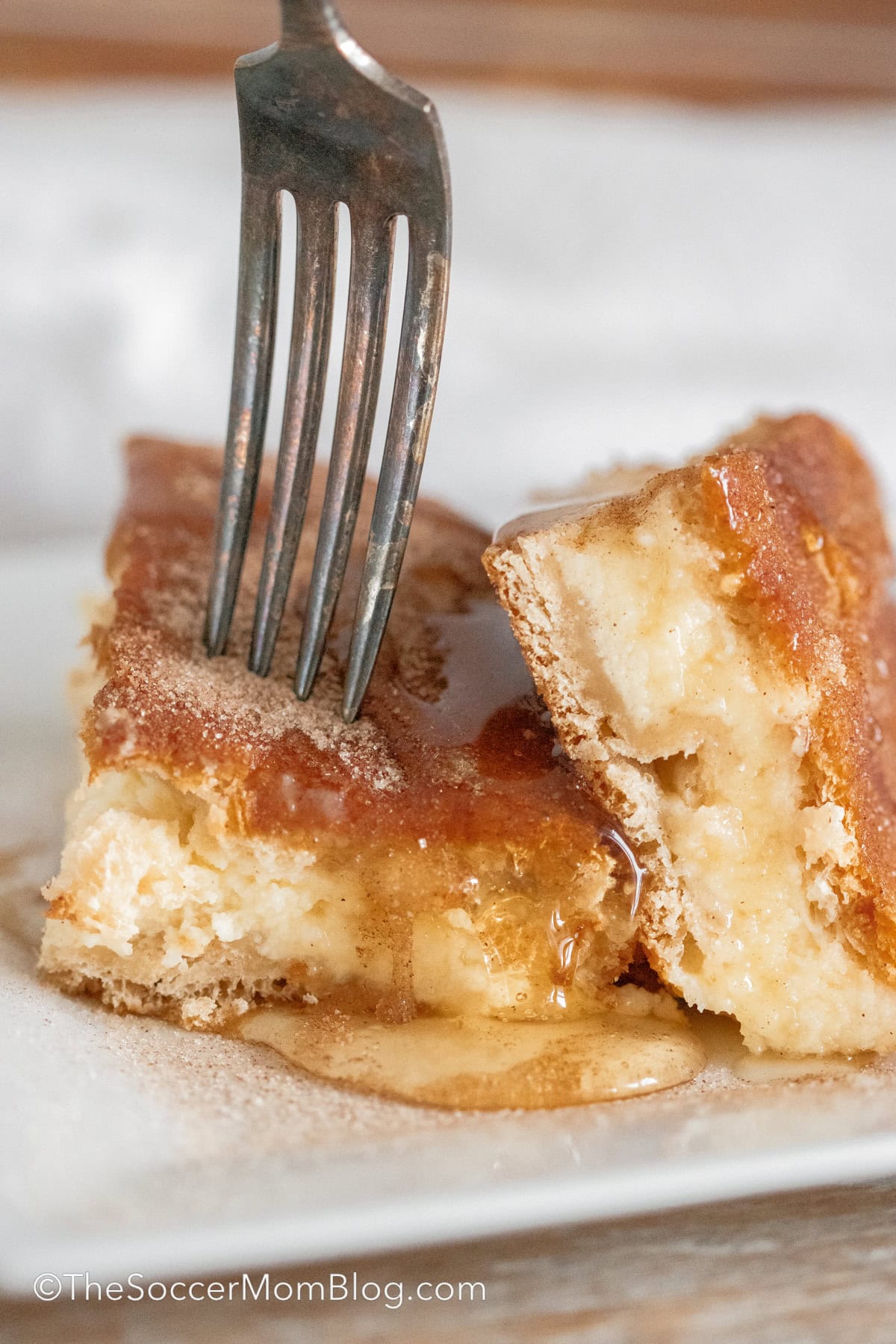 fork taking bite of churro cheesecake bar.