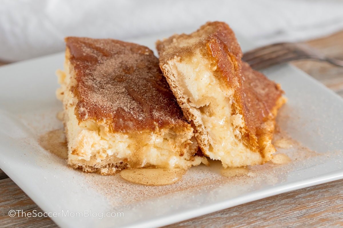 two churro cheesecake bars on a plate.