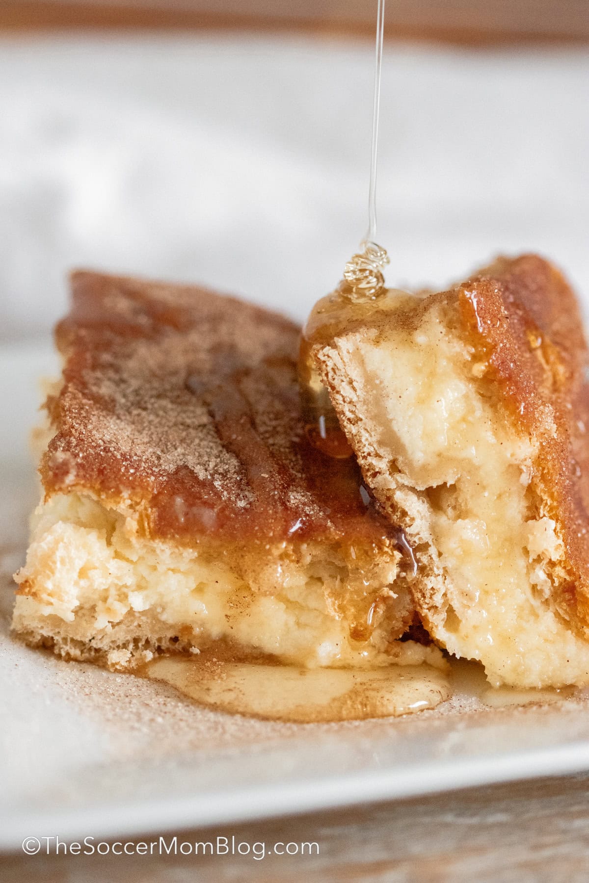 drizzling honey on churro cheesecake squares.