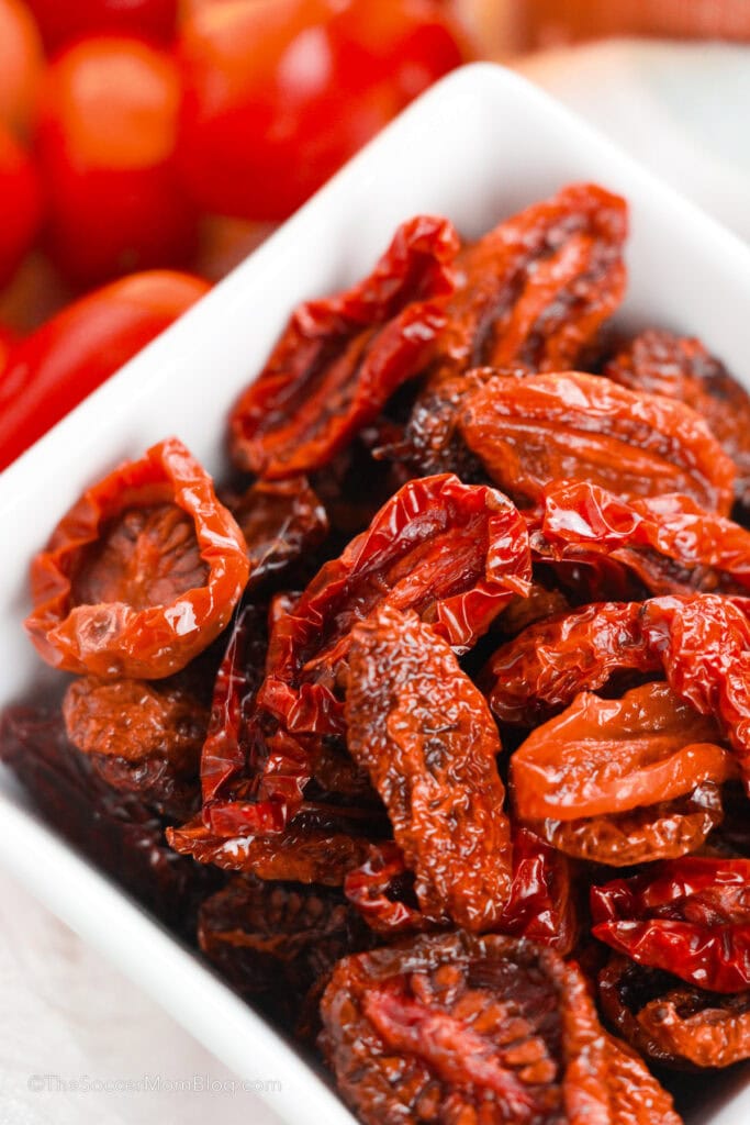 Sun dried tomatoes in a square white bowl.