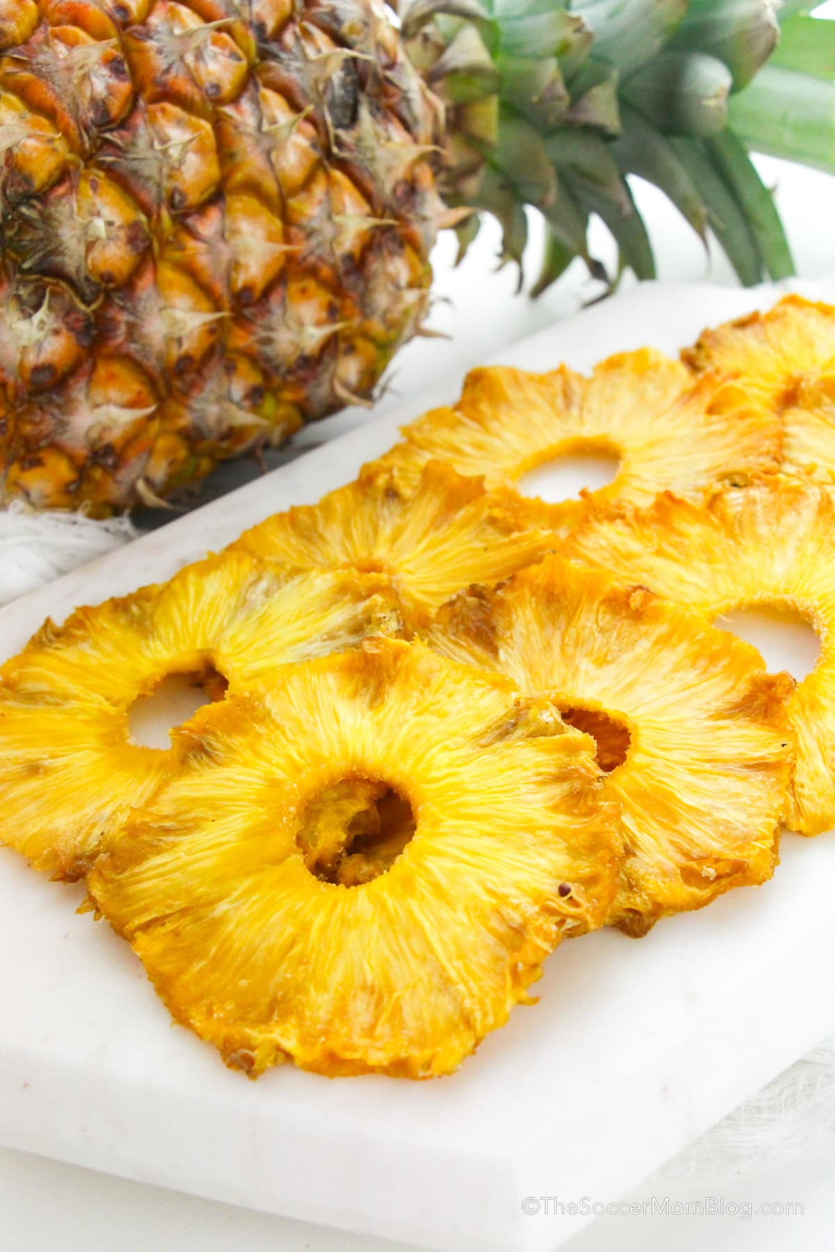 Oven dried pineapple slices laid neatly on a serving plate.
