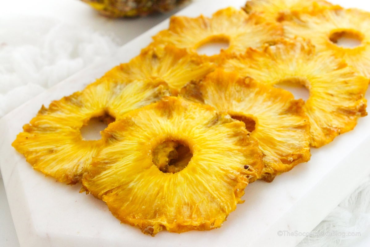 Oven dried pineapple slices on a serving plate.