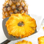 A dried pineapple slice on a metal spatula.