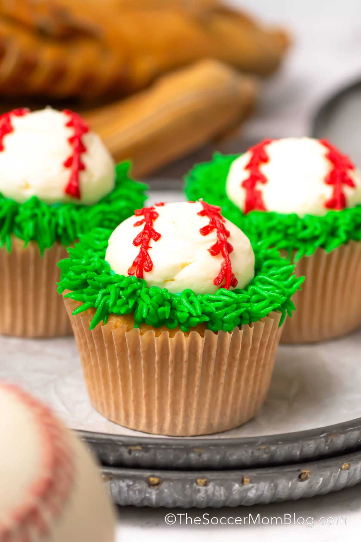 Three Baseball Cupcakes on a baking tray.