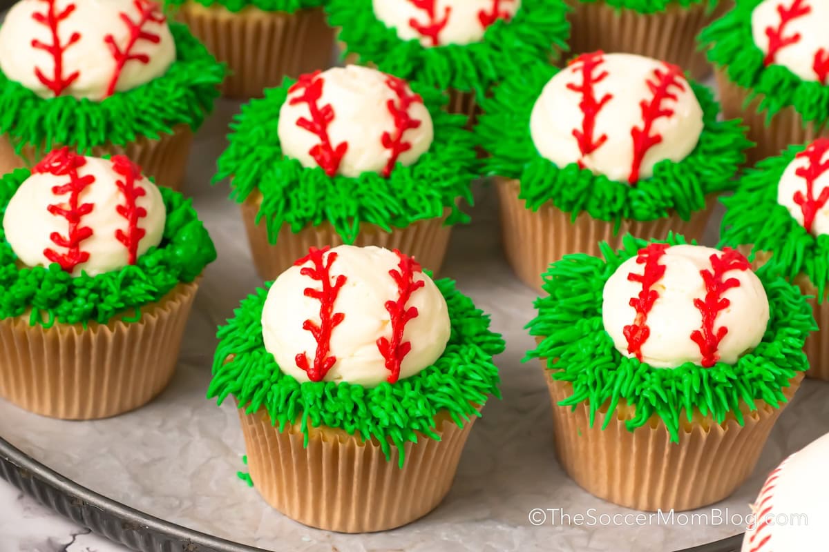 Baseball Cupcakes on a parchment line baking sheet.
