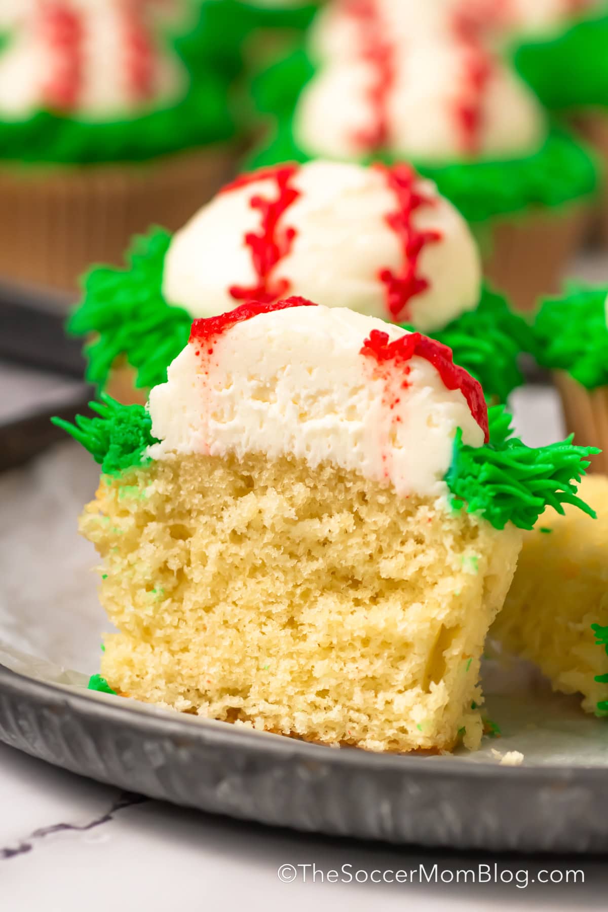close up of a baseball themed cupcake that's been cut in half.