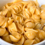 close up on a bowl of homemade shells and cheese.