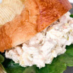 close up of chicken salad served on a croissant.