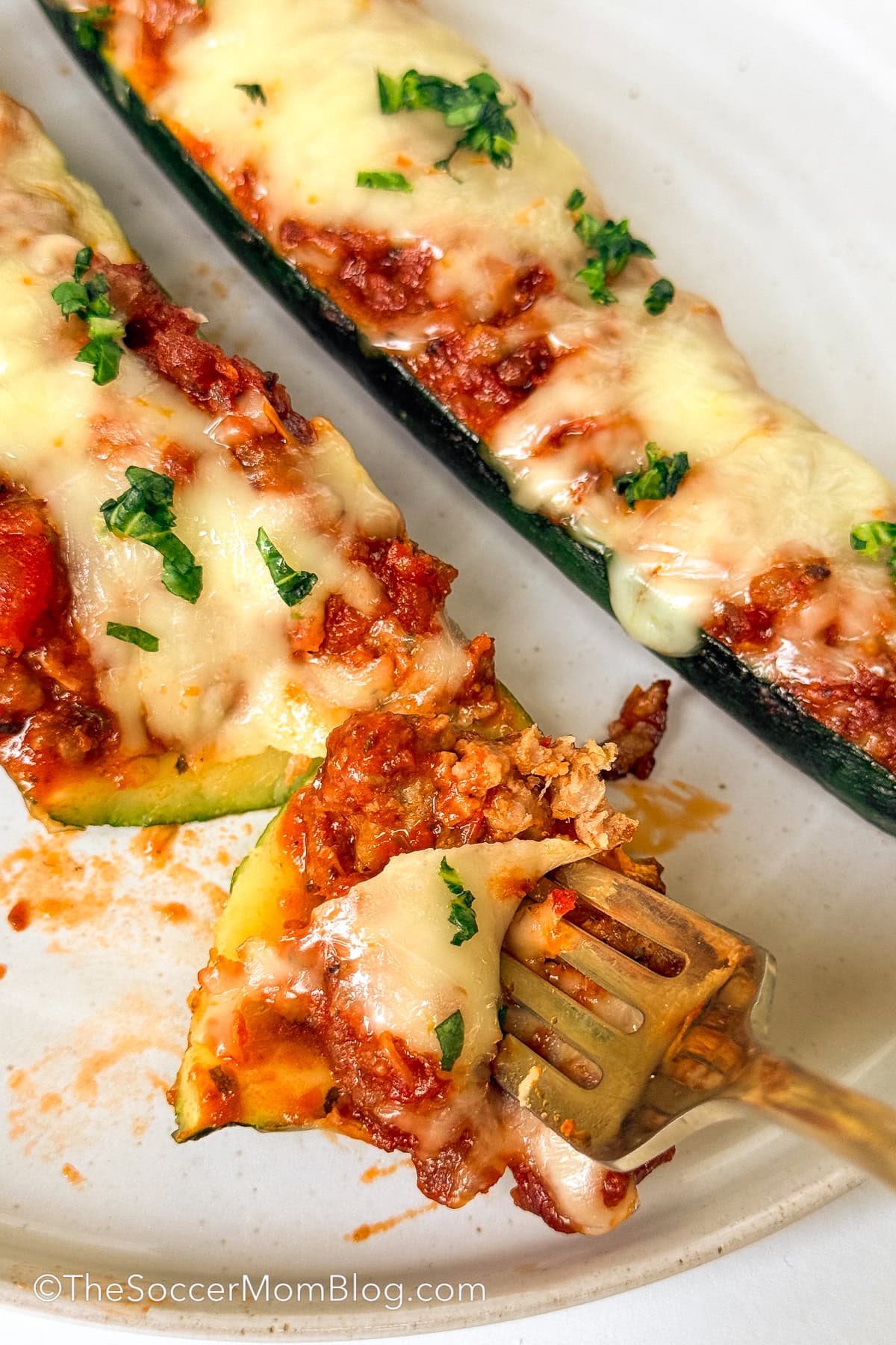taking a bite of a stuffed zucchini.